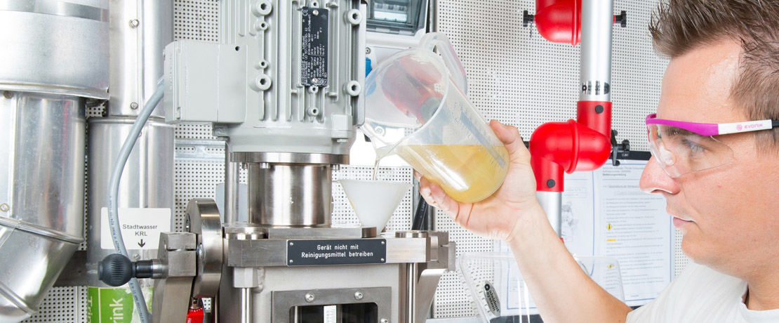 technician pouring liquid into lab machine