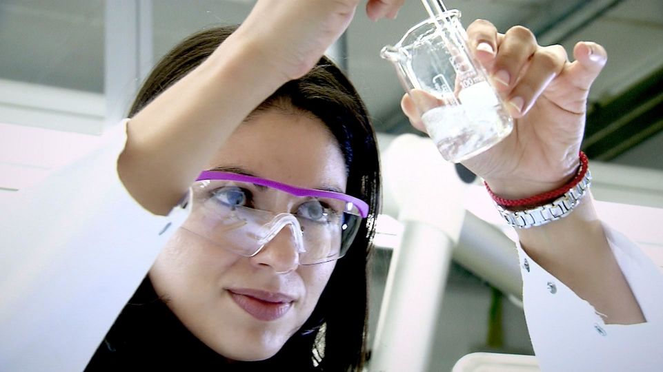 Scientist examining liquid in vial