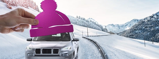 Car with winter hat driving on snowy road
