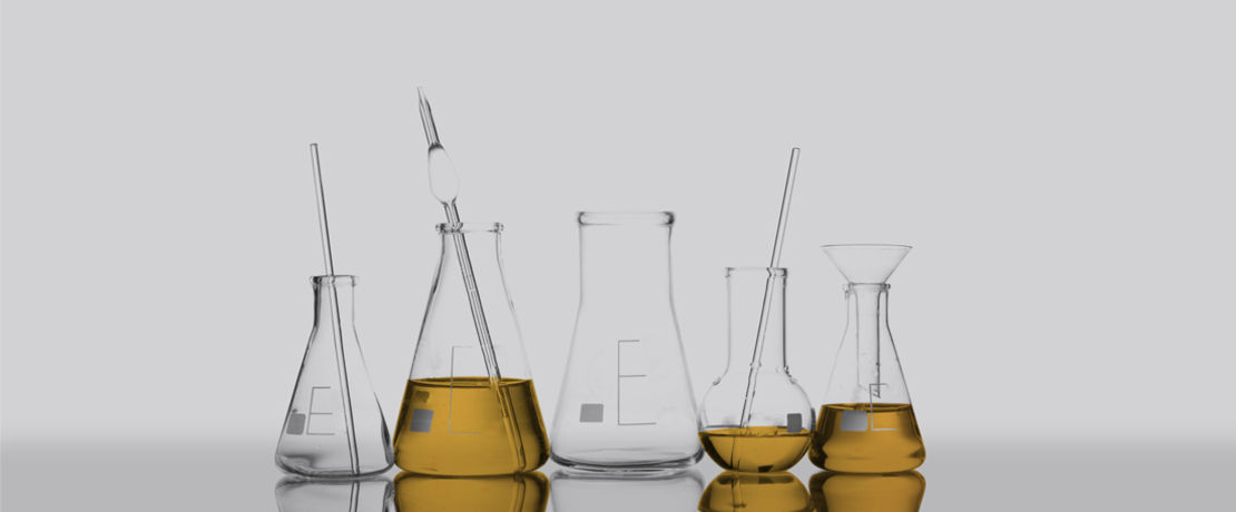 Several lab beakers and vials holding liquid.